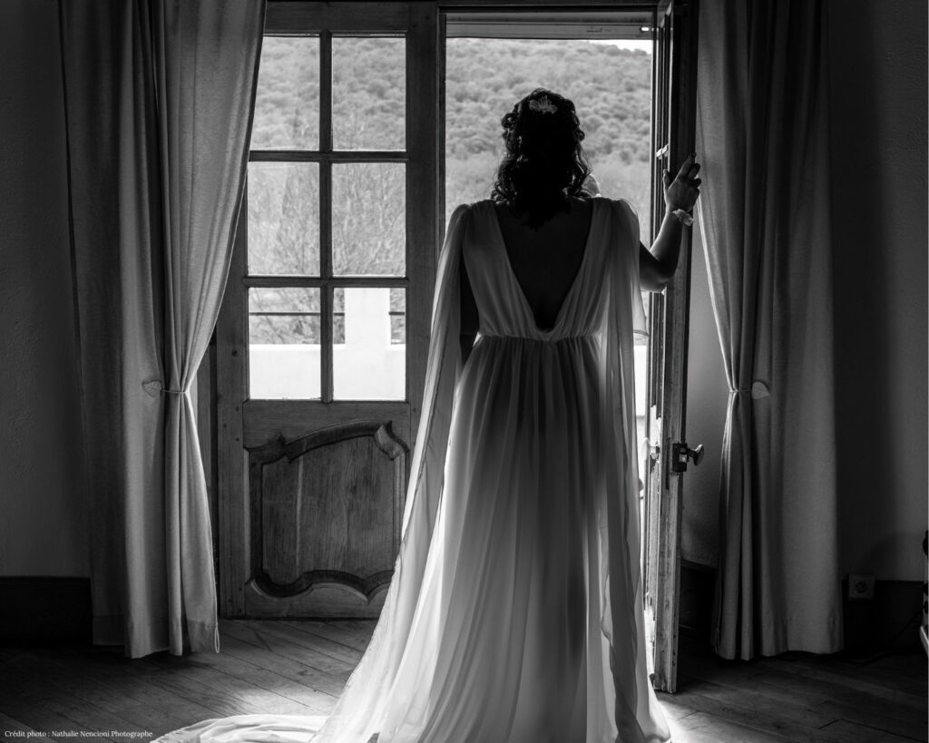 Mariée de dos face à une porte-fenêtre ouverte sur les collines, photo noir et blanc, Domaine du Planet, Pourrières, Var