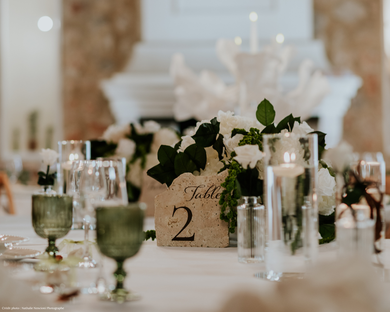 Table de réception dressée avec fleurs blanches, bougies et numéro de table en pierre, mariage Domaine du Planet, Var