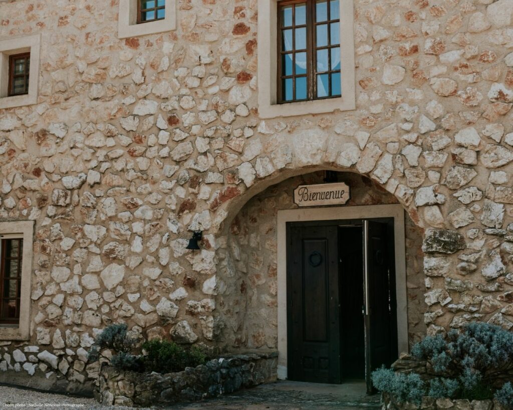 Façade en pierre avec porte d'entrée ouverte et écriteau Bienvenue, Domaine du Planet, Pourrières, Var